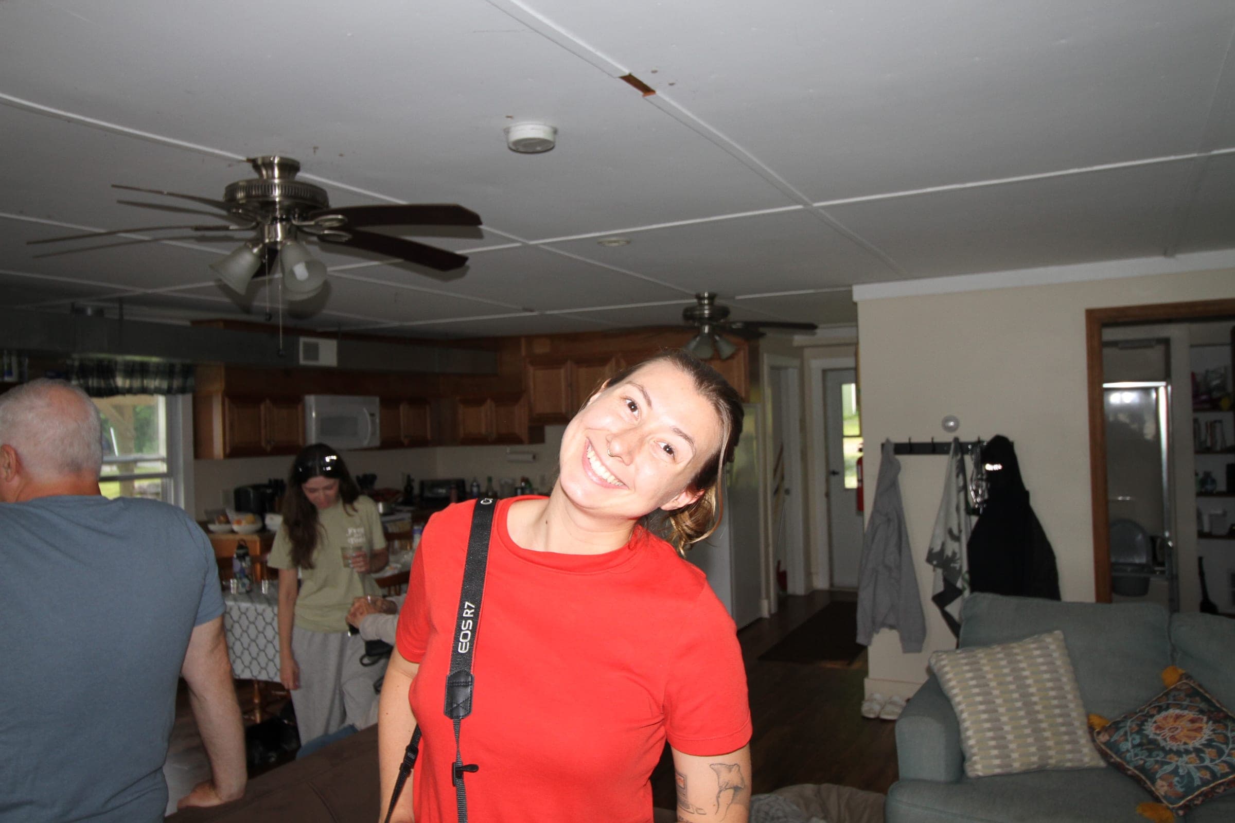 Victoria in a red top in a wood-panelled room, smiling over her shoulder.